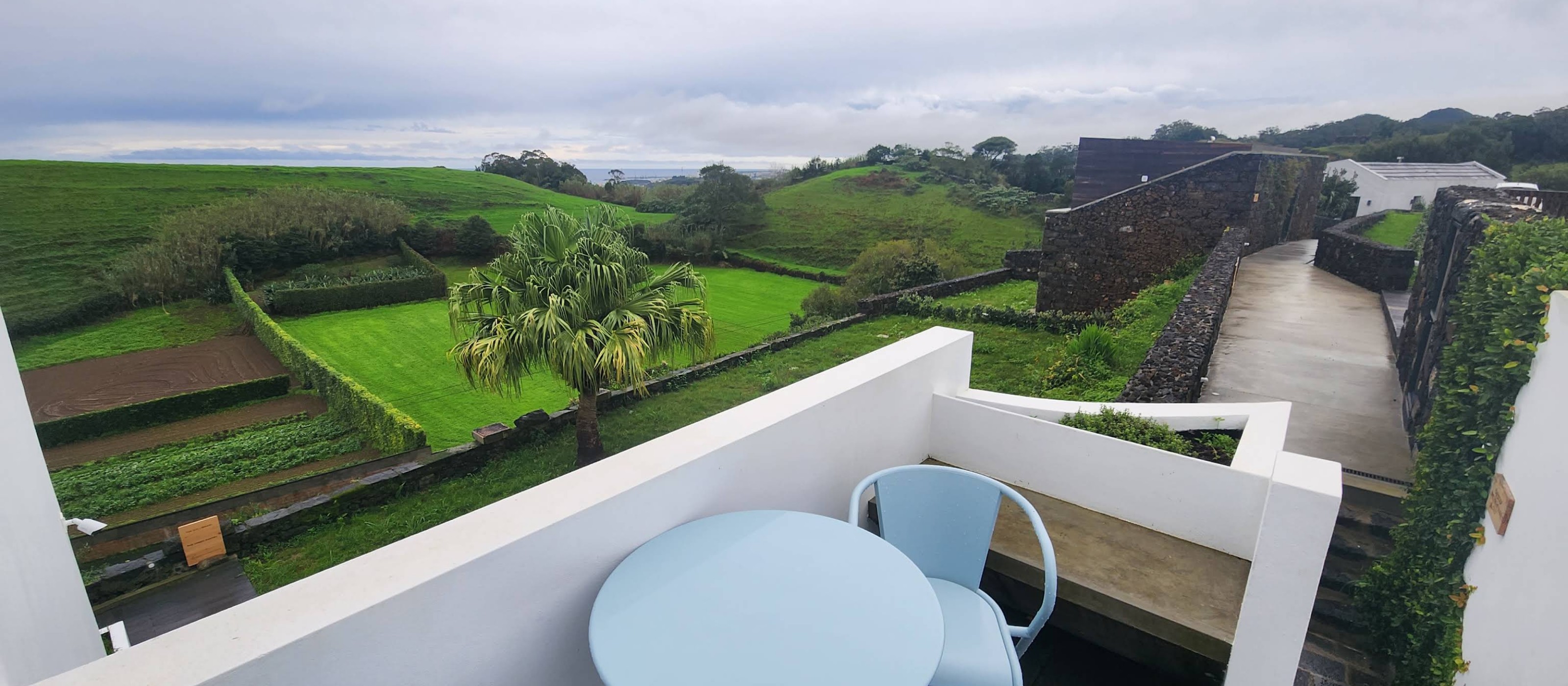 View from a suite terrace over the estate gardens and hills to the sea
