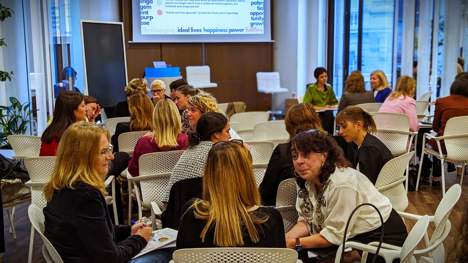 Participants in conversation around tables during the workshop