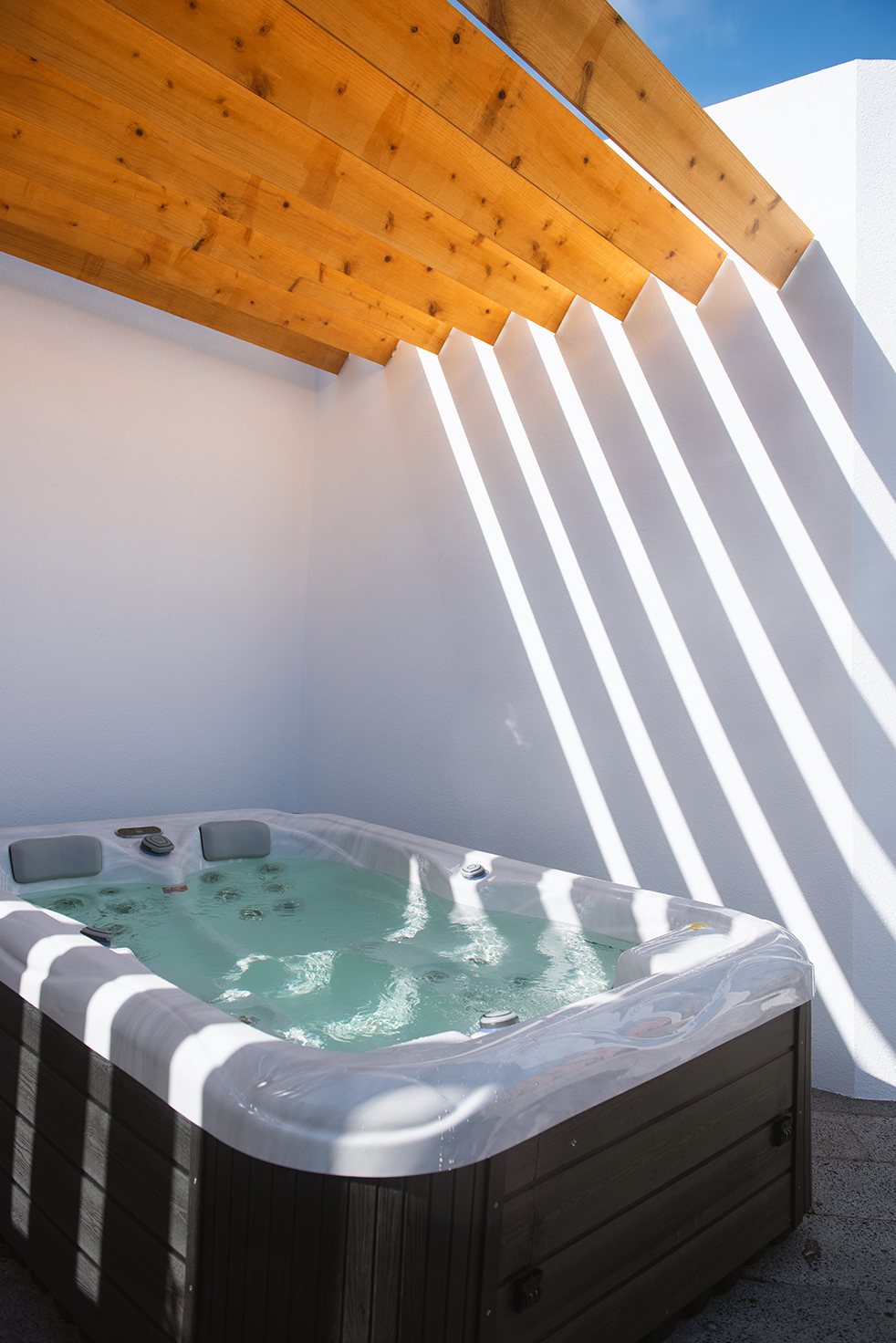 A private jacuzzi under a wooden pergola at Vilas do Olival
