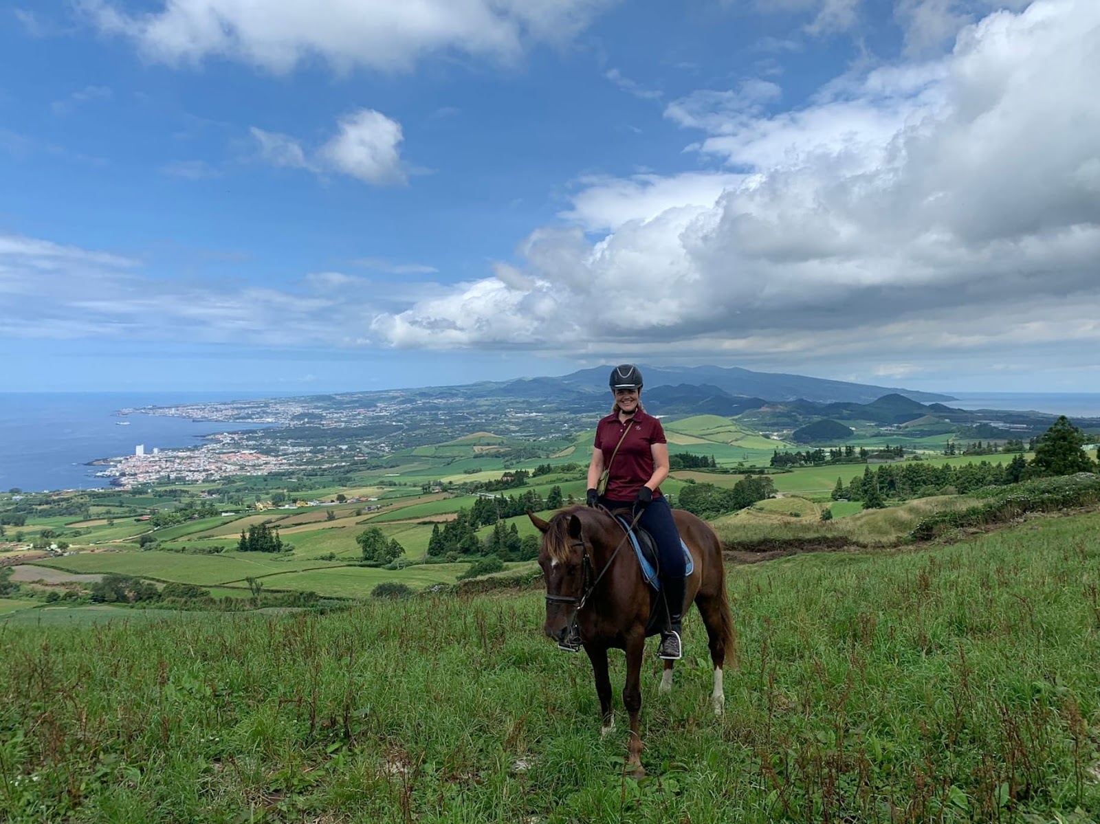 Horseback riding across green hills above the north coast of Sao Miguel