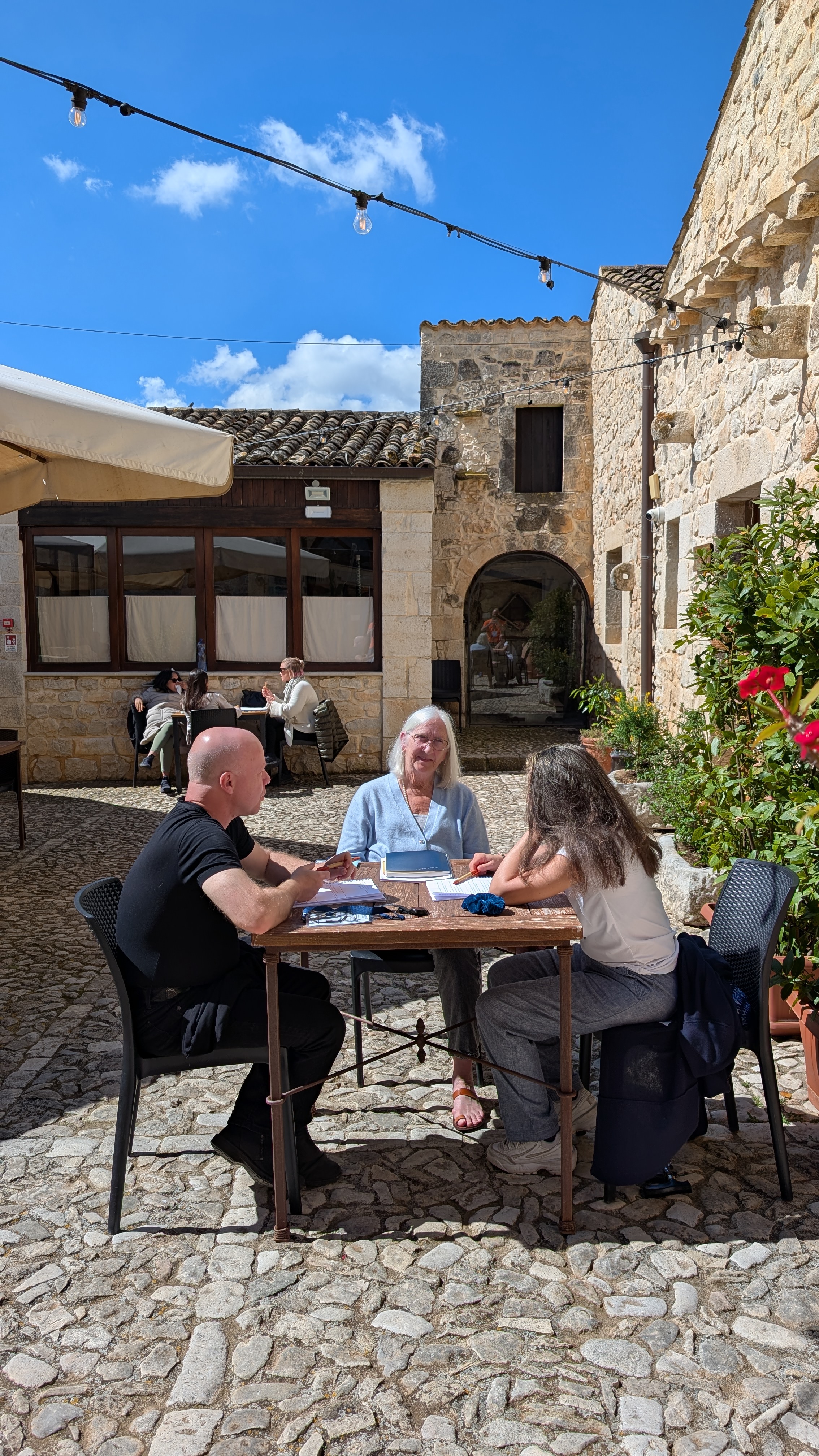 A retreat guest walking through a sunlit stone courtyard