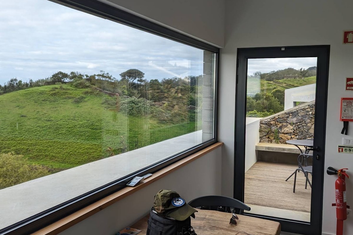 A suite living space with a picture window over the green hills