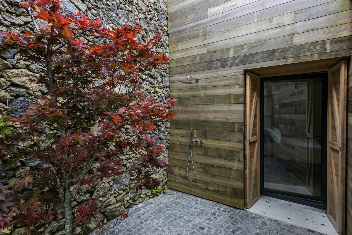 The outdoor shower at the Ruin, beside a stone wall and red maple