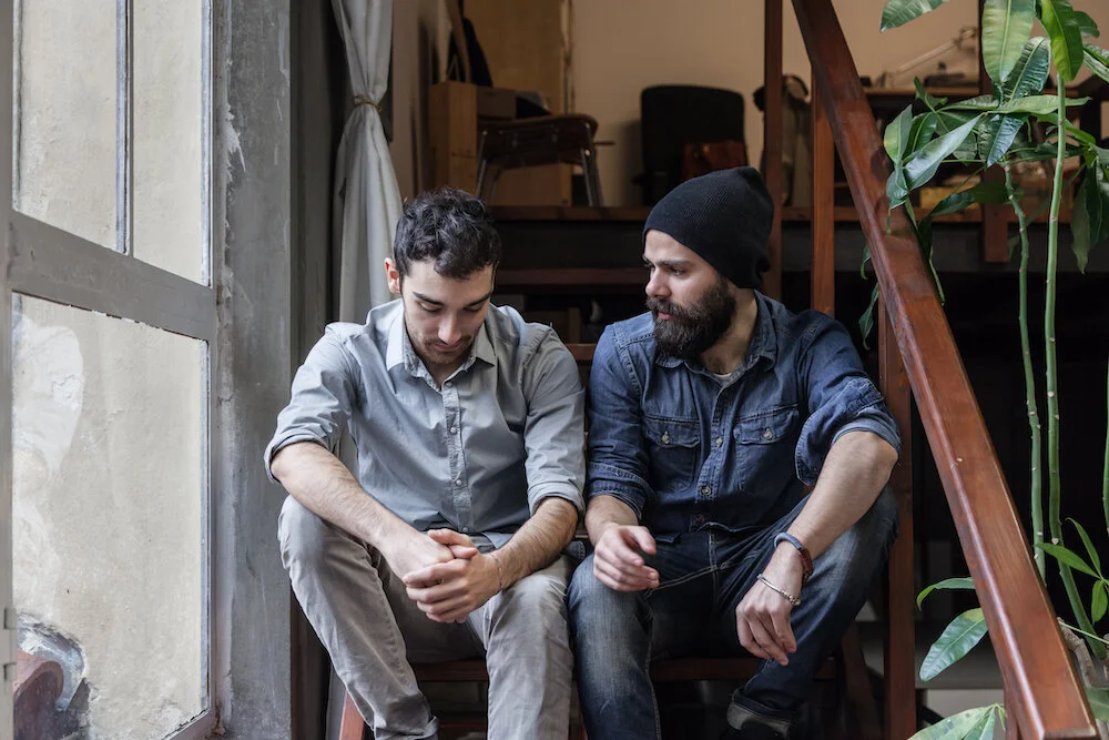 two males sitting on stairs discussing personal growth programs.jpg